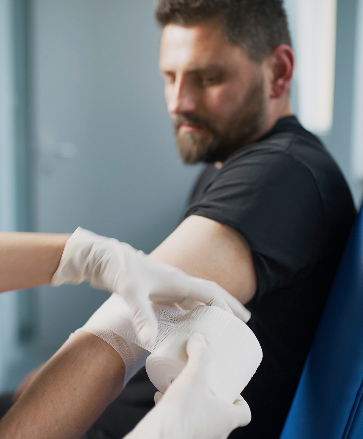 Applying a bandage to a patient's arm.
