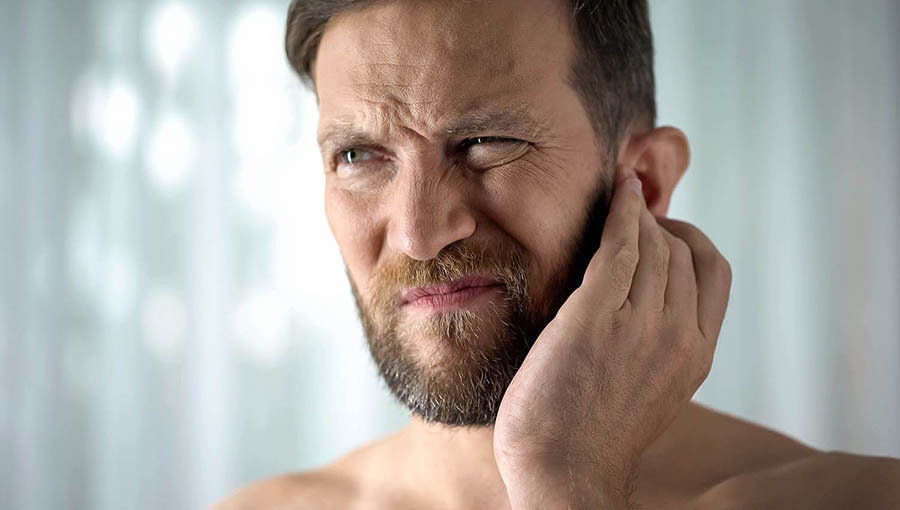 patient for general surgery in San Bernardino holding ear