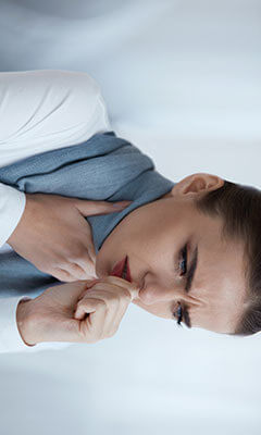 woman coughing and holding her throat